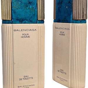 Könnte beinhalten: Zwei Vintage-Flakons von Balenciaga Pour Homme Eau de Toilette. Die rechteckigen Flakons haben einen cremefarbenen Körper mit vertikalen Rillen und einen türkisfarbenen Deckel mit goldenen Akzenten. Der Markenname und die Produktdetails sind aufgedruckt.