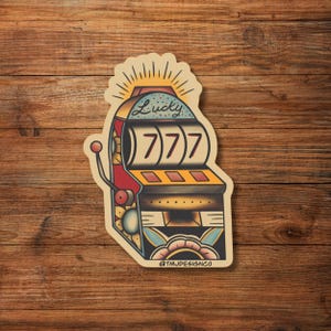 May include: A sticker featuring a vintage-style slot machine design. The machine is red, yellow, and blue, with the word "Lucky" above the reels displaying "777". The design includes a sunburst and floral elements.