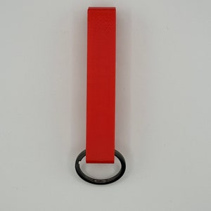 May include: A bright red leather keychain with a black metal ring.