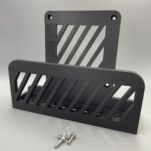 Peut inclure: Organisateur mural noir avec un motif géométrique et des fentes pour ranger des objets. Il est livré avec quatre vis argentées pour le montage.