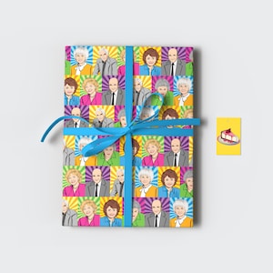 Peut inclure: Cadeau emballé avec un motif pop art coloré de portraits de personnages. Le papier cadeau présente un motif répété de visages dans des carrés vifs. Un ruban bleu clair est noué autour du cadeau. Une étiquette jaune avec une illustration de gâteau est attachée.
