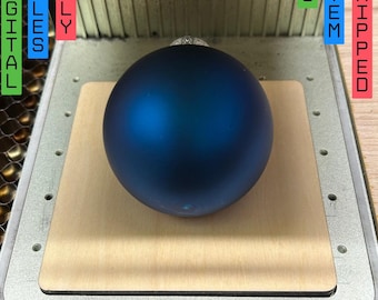May include: A blue Christmas ornament on a wooden base. The ornament is round and smooth. The base is light brown and has a rectangular shape. The text "ONLY DIGITAL FILES" is visible in the image.