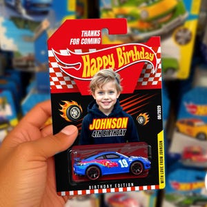 May include: A blue toy car with the number 19 on the side, packaged in a red and black card with the text "Happy Birthday" and a child's photo. The card also says "Birthday Edition" and "Thanks for coming."