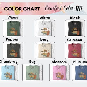 Op de afbeelding: Kleurenkaart van Comfort Color 1717 t-shirts in kleuren als Moss, White, Black, Pepper, Ivory, Crimson, Chambray, Bay, Blossom en Blue Jean. Elk shirt heeft een tropisch ontwerp met een palmboom, vlag en bloemen.