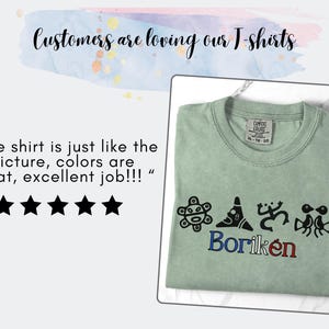 May include: A sage green t-shirt with the word "Borik&eacute;n" in blue and red embroidery. The shirt features four black graphic designs above the word. The text "Customers are loving our T-shirts" is at the top.
