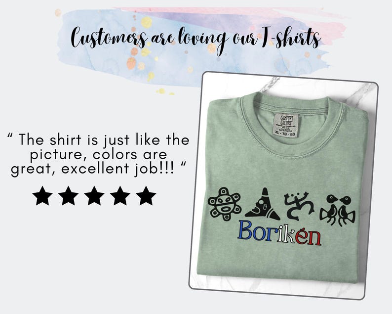 May include: A sage green t-shirt with the word "Borik&eacute;n" in blue and red embroidery. The shirt features four black graphic designs above the word. The text "Customers are loving our T-shirts" is at the top.