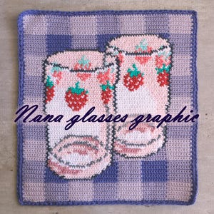 Puede incluir: Un cuadrado de ganchillo con dos vasos con diseños de fresas. Los vasos son rosas con fresas rojas y verdes. El fondo es un patrón de cuadros en tonos morados y azules. El texto "Nana glasses graphic" está escrito en la parte inferior.