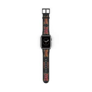May include: Black Apple Watch with a black strap featuring the words "STRONG" and "AFRAID" in red and yellow. The text "Joshua 1:9" is also printed on the strap. The watch has a black square face.