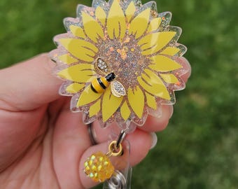 Sunflower badge reel with bee charm. Multiple color options. Matching bead charm.