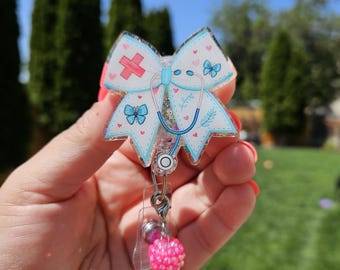 Bow Badge Reels. Seasonal, floral, medical bows. All styles come with a matching bead charm.