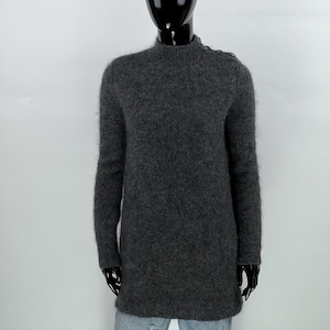May include: A gray mock neck sweater with long sleeves and button details on the shoulders.
