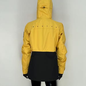 May include: Yellow and black hooded jacket with the word "MONTEC" printed across the back. The jacket has a yellow upper section and a black lower section. The jacket has a hood and long sleeves.