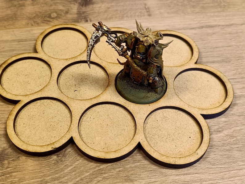 Puede incluir: Una bandeja de exhibici&oacute;n de figuras en miniatura de madera con ocho recortes circulares. Una figura en miniatura detallada con una guada&ntilde;a se coloca en la bandeja. La figura est&aacute; pintada en tonos de verde, marr&oacute;n y plata. La bandeja es de madera marr&oacute;n claro.