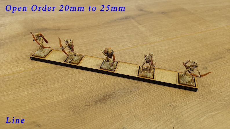 May include: A line of six miniature skeletal figures holding bows and arrows, standing on a wooden base. The base is labelled "Open Order 20mm to 25mm Line".