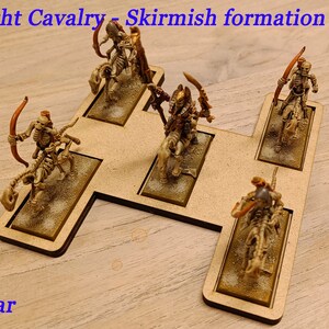 May include: A set of five skeletal cavalry miniatures in a skirmish formation on a wooden base. The miniatures are painted in a bone white color with gold accents. The base is painted in a light brown color. The text "Light Cavalry - Skirmish formation" is printed on the base. The text "Star" is printed below the base.