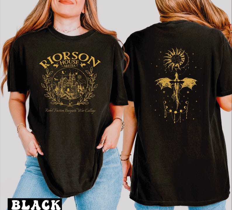 A woman wearing a black t-shirt with a graphic design on the front and a dragon and sun motif on the back.