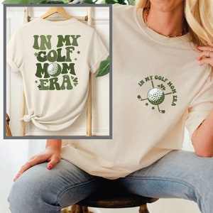 a woman sitting on a chair holding a t - shirt