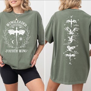 A woman wearing a green t-shirt with a graphic design featuring a dragon and the text "WINGLEADER RIDERS IN WING".