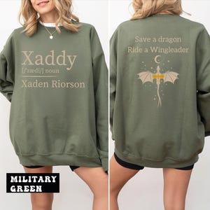 A woman wearing a green sweatshirt with text and graphics on the back.