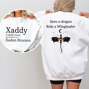 A person wearing a white sweatshirt with a dragon and text printed on the back.