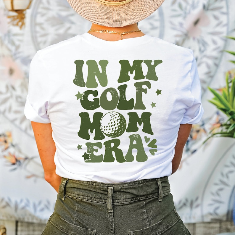 a woman wearing a hat and a tee shirt that says in my golf mom era