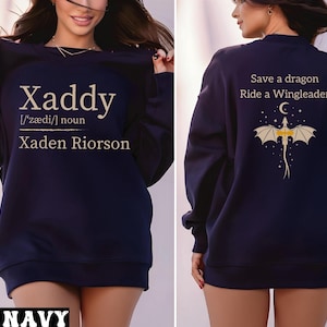 A woman wearing a navy blue sweatshirt with the text "Xaddy" and "Xaden Rierson" printed on it. The sweatshirt also features a dragon and a moon graphic.