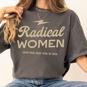 a woman sitting on a chair wearing a t - shirt that says radical women