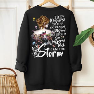 a black sweatshirt with a picture of a woman with flowers on it