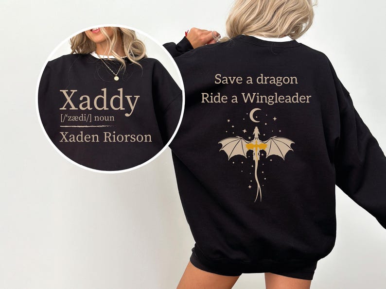 a woman wearing a black sweatshirt with a dragon design and text printed on the back.