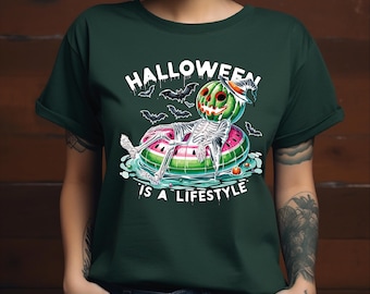 May include: A green t-shirt with a graphic of a skeleton wearing a watermelon costume and floating on a watermelon pool float. The text "Halloween is a lifestyle" is printed below the graphic.