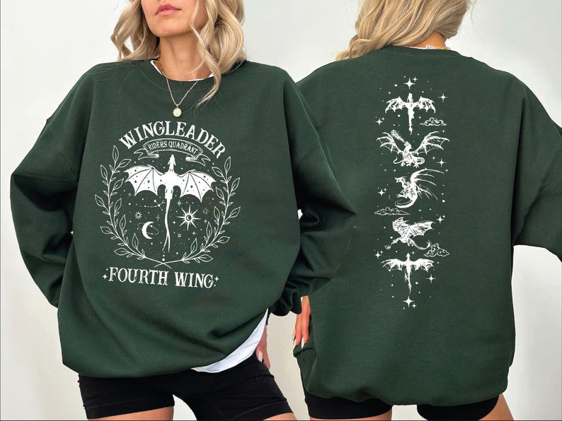 A woman wearing a green sweatshirt with a graphic design featuring a dragon and the text "WINGLEADER" and "FOURTH WING".