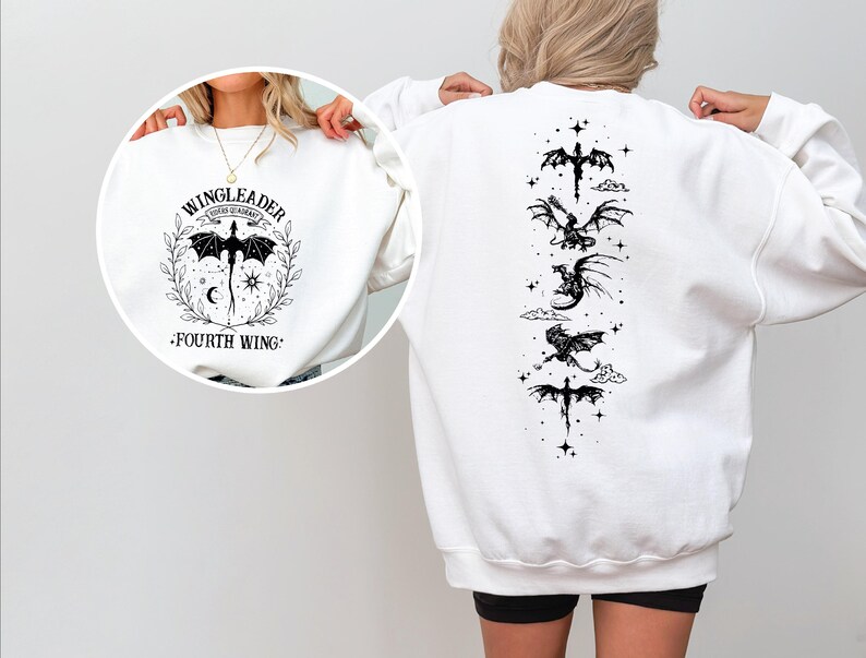 A person wearing a white sweatshirt with a graphic design featuring a dragon and stars on the back.