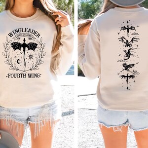 A woman wearing a white sweatshirt with a graphic design on the front and a back view of the design.