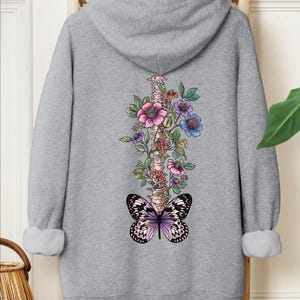 a sweatshirt with a butterfly and flowers on it