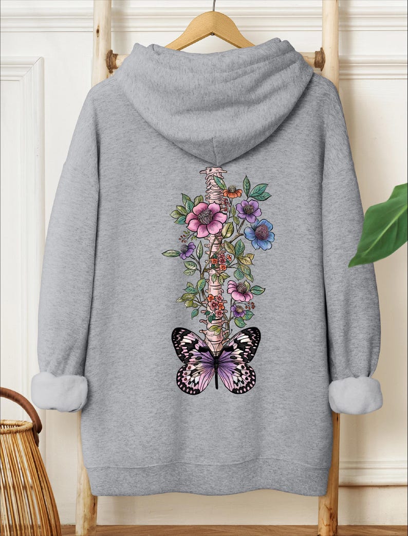 a sweatshirt with a butterfly and flowers on it