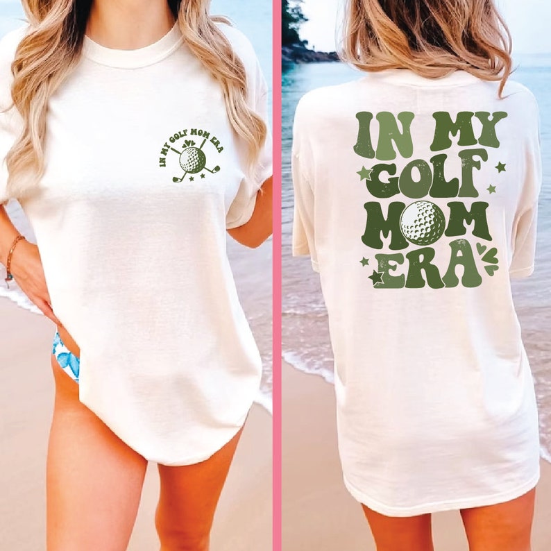 a woman standing on a beach wearing a shirt that says in my golf mom era