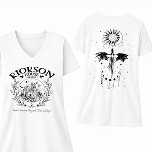 a white t-shirt with a graphic design on the front and back. The front design includes a castle and a sun, while the back design features a dragon and a sun.