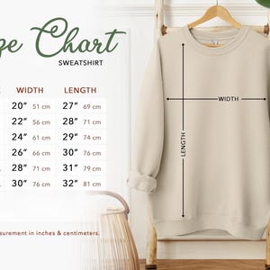 a size chart for a sweatshirt hanging on a wall
