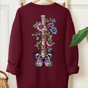 a red sweatshirt with a butterfly and flowers on it