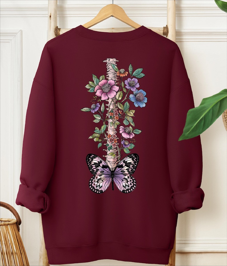 a red sweatshirt with a butterfly and flowers on it
