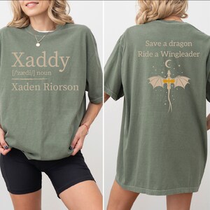 a woman wearing a green t-shirt with a dragon design and text printed on the back.