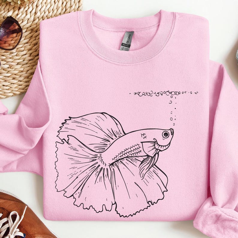 a pink shirt with a drawing of a fish on it