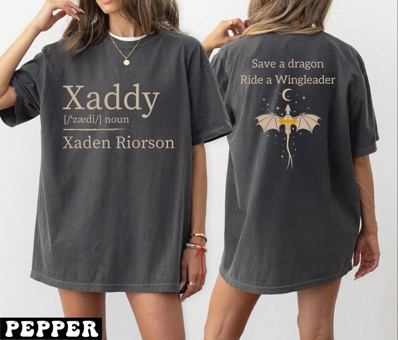 A woman wearing a gray t-shirt with text and a dragon graphic on the back.