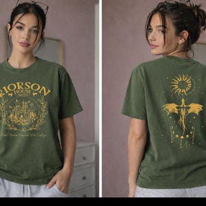 A woman wearing a green t-shirt with a graphic design on the front and back.
