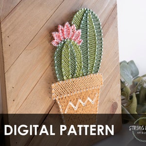 K&ouml;nnte beinhalten: Ein digitales Muster f&uuml;r String Art mit einem Kaktus in einem Topf. Der Kaktus ist gr&uuml;n und hat eine rosa Bl&uuml;te. Der Topf ist gelb. Das Muster ist auf einem Holzgrund. Der Text "DIGITAL PATTERN" befindet sich am unteren Rand des Bildes.
