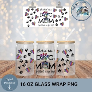 May include: Three clear glass tumblers with bamboo lids and straws, decorated with paw prints and rainbow leopard print hearts. The central tumbler reads "Rockin' the Dog Mom Spoiled wife life." A sign above repeats the design. The tumblers are 473 ml.
