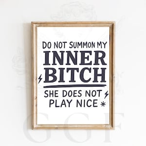 May include: A framed print with the text "DO NOT SUMMON MY INNER BITCH SHE DOES NOT PLAY NICE." The text is in a bold, sans-serif font, with lightning bolt and asterisk symbols. The frame is a light brown color.