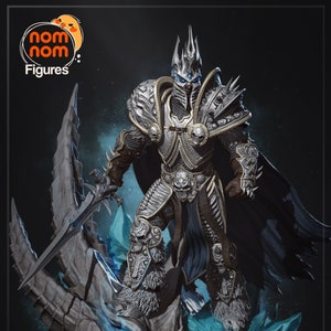 May include: A detailed figurine of the Lich King from World of Warcraft, standing on a frozen dragon skull. The Lich King is wearing a crown and armour, and holding a sword. The figurine is painted in a silver and blue colour scheme.
