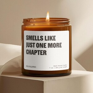 Peut inclure: Un pot de bougie en verre brun allumé avec une étiquette blanche qui dit "SMELLS LIKE JUST ONE MORE CHAPTER". La bougie est de 200 g et coulée à la main. La marque "HIGHS&JOWS" est imprimée sur l'étiquette.