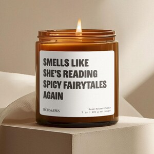 Peut inclure: Une bougie parfumée faite à la main dans un bocal en verre brun. L'étiquette blanche indique "SMELLS LIKE SHE'S READING SPICY FAIRYTALES AGAIN". La bougie pèse 200 g net.